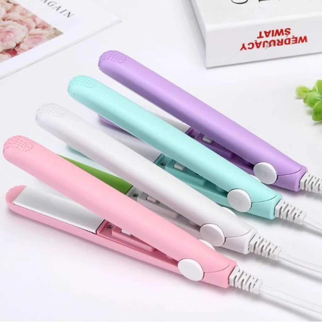 Mini hair straightener in pastel pink color with white cord shown at an angle on a white background